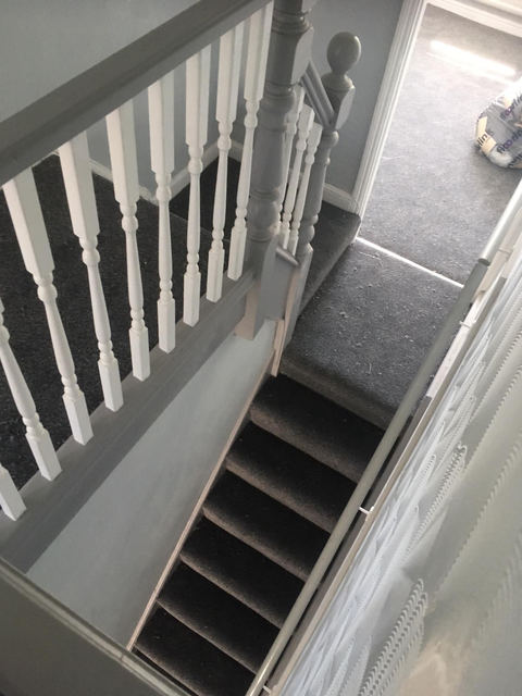 Staircase with white painted spindles seen from the landing